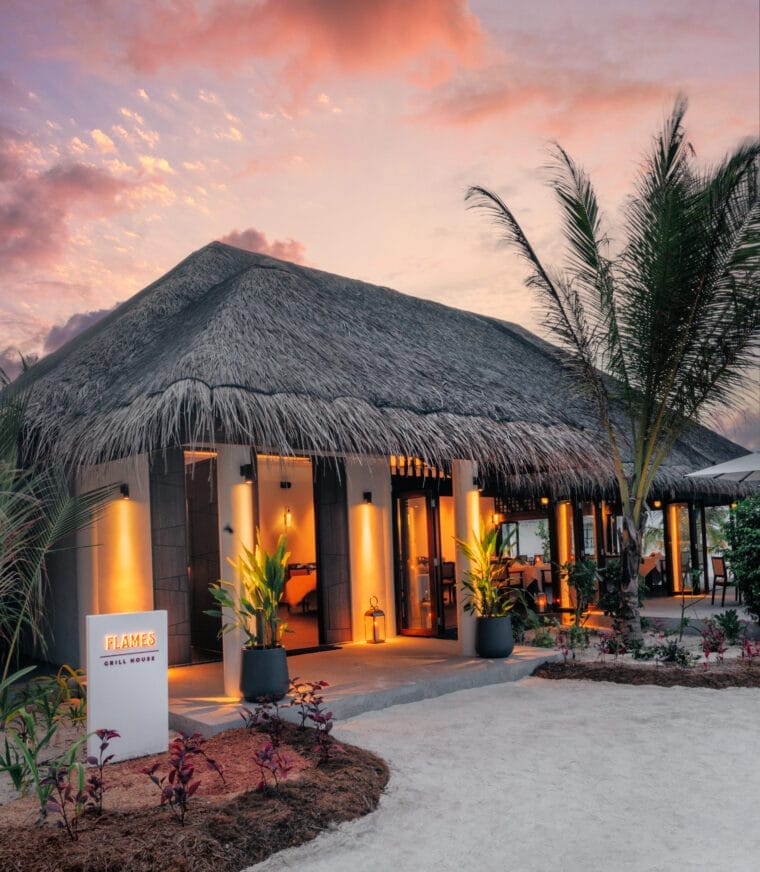 a restaurant with palm trees and a sign saying Flames Grill House