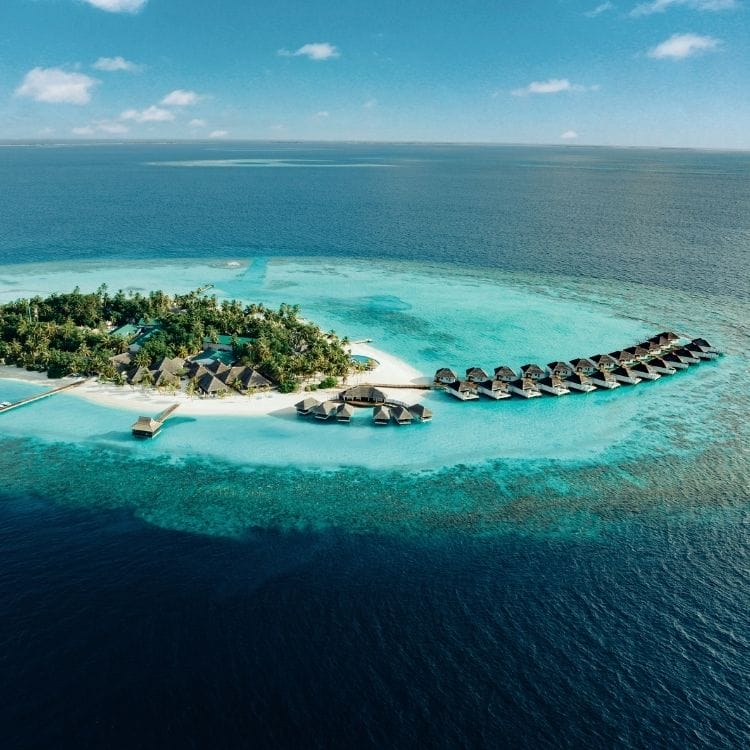 Aerial of Nova Maldives, small natural island with greenery and expansive lagoon