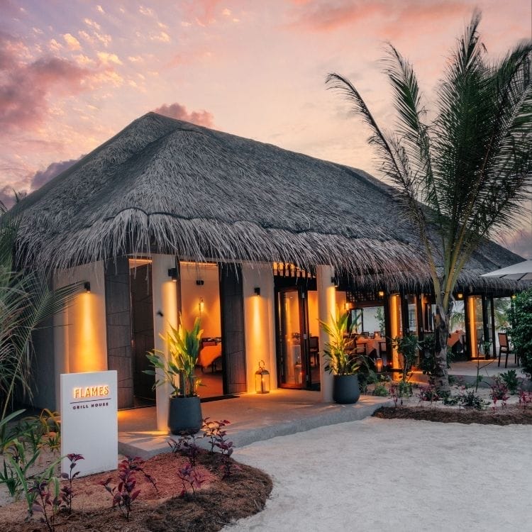 a restaurant with palm trees and a sign saying Flames Grill House