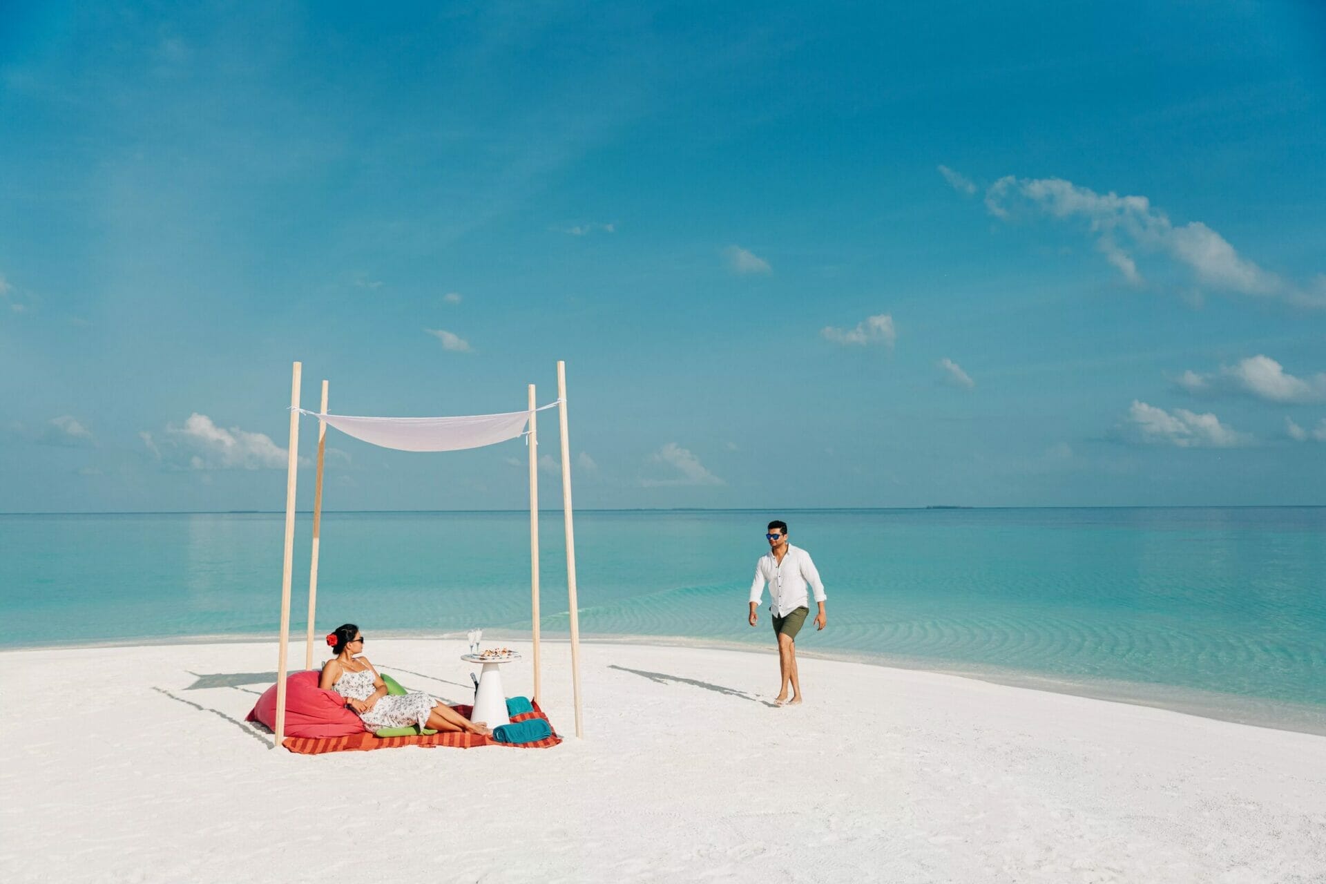 Un couple sur un banc de sable avec une configuration déjeuner