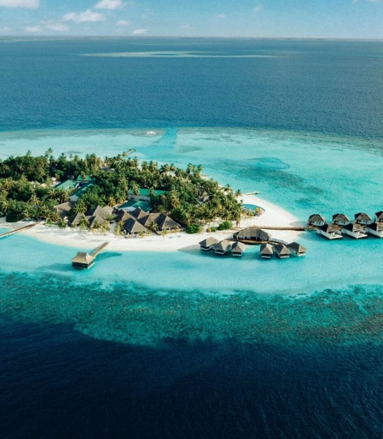 Aerial of Nova Maldives, small natural island with greenery and expansive lagoon