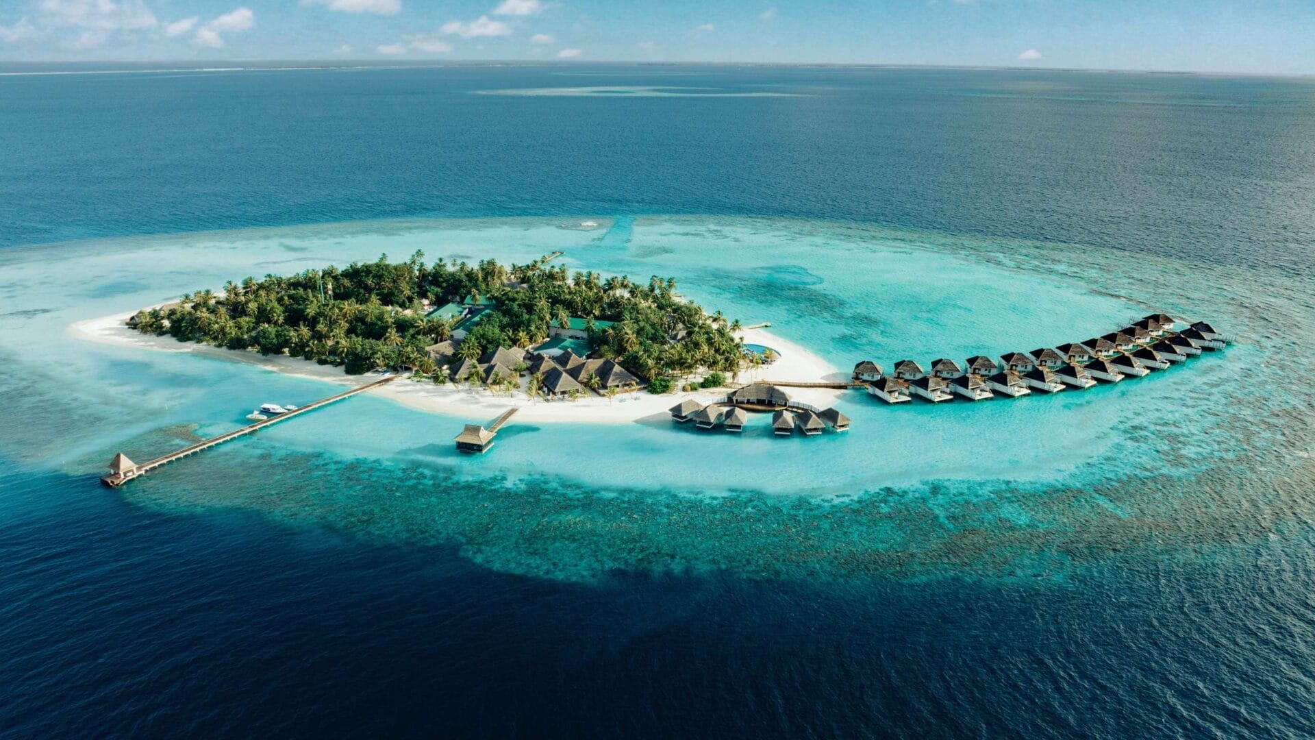 Aerial of Nova Maldives, small natural island with greenery and expansive lagoon