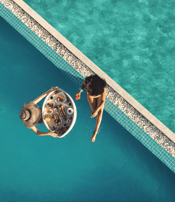 Two girls enjoying a floating breakfast at their private pool at Nova Maldives