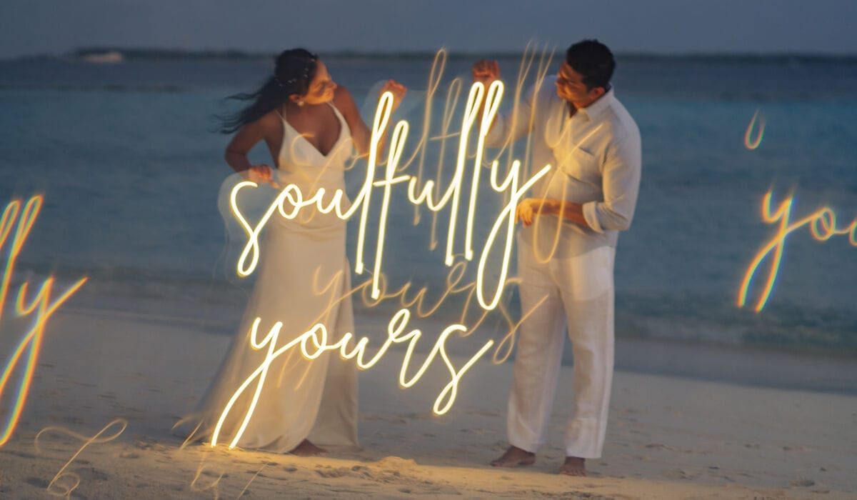 A couple holding up a sign that says "Soulfully Yours"