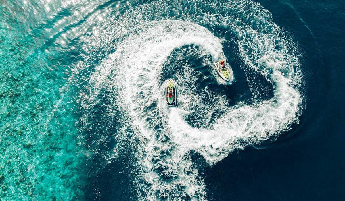 Two jet-skis going in circles on the blue lagoon of Nova Maldives