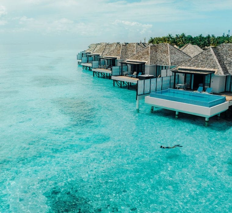 Exterior of water pool villa with a snorkeller in the water