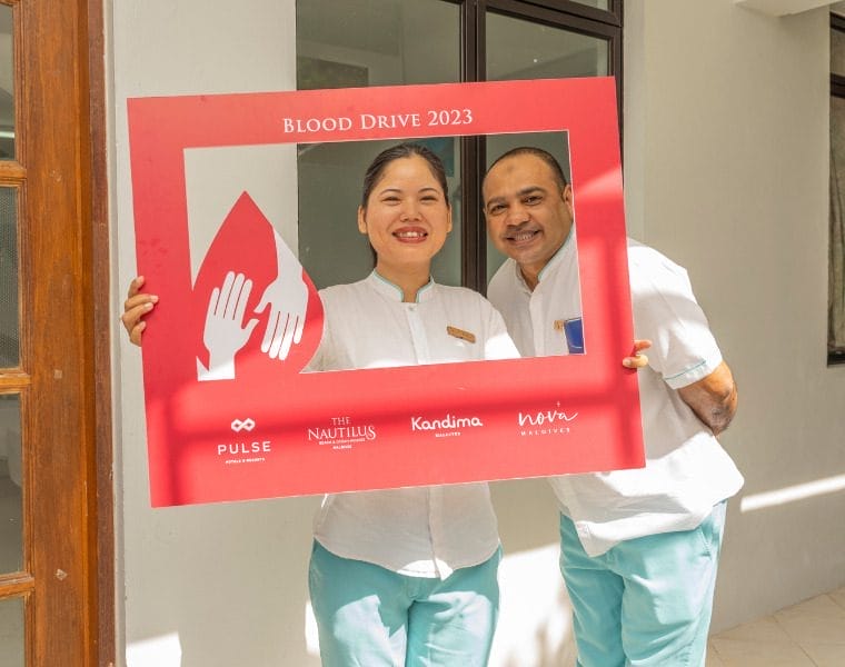 Nova staff holding a blood drive signage