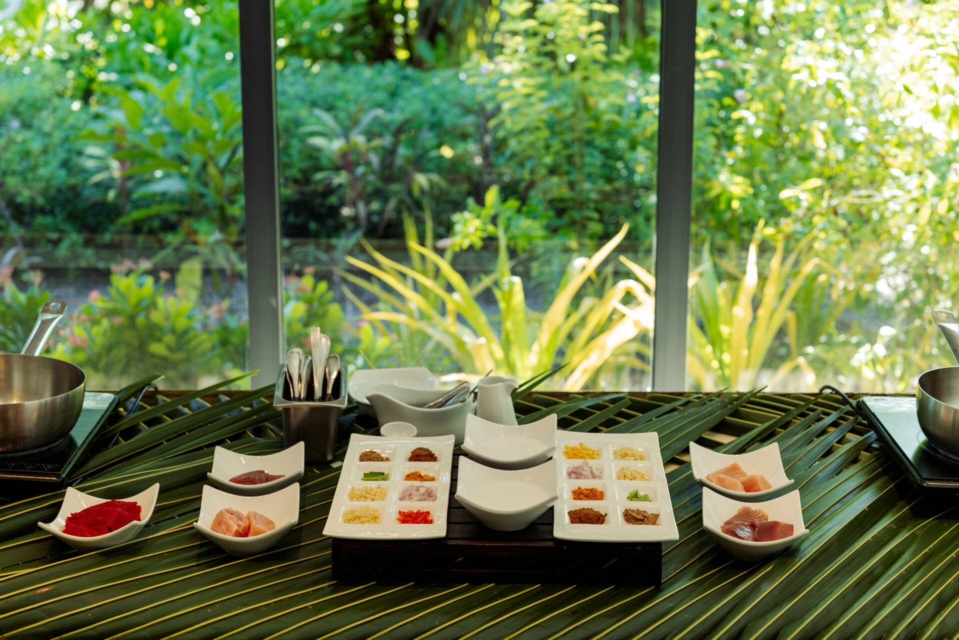 Ingredients laid out in an open-air dining area with green surroundings.