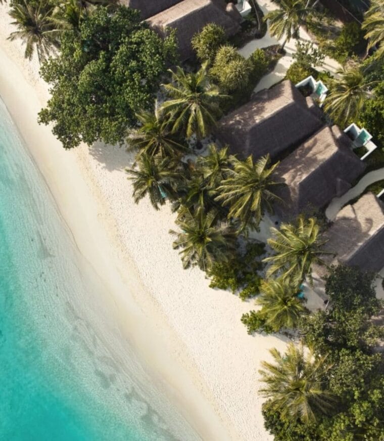 A stunning aerial view of Nova Maldives, showcasing its white sandy beaches, lush greenery, and turquoise waters along the shoreline.