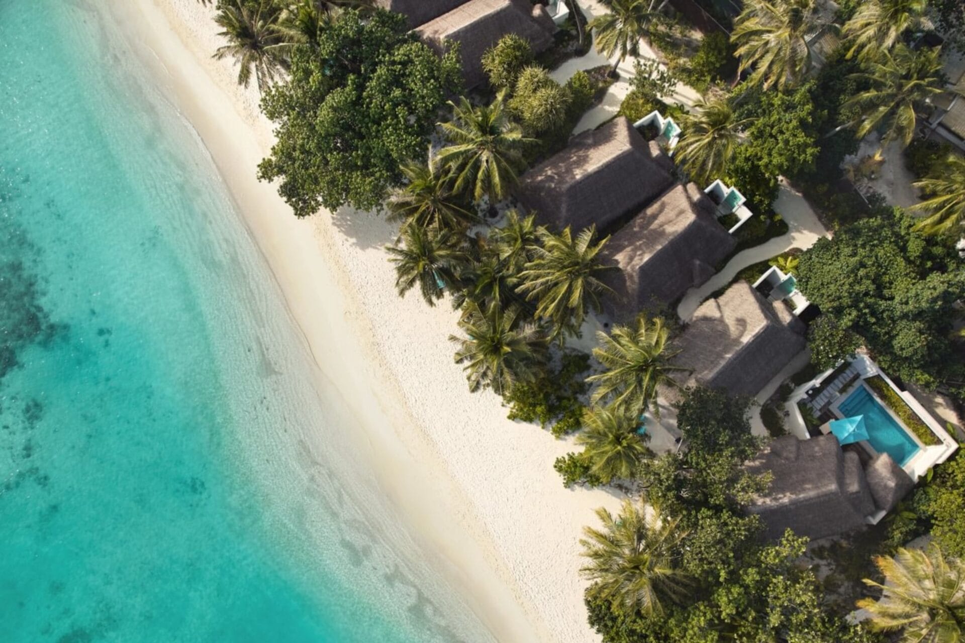 A stunning aerial view of Nova Maldives, showcasing its white sandy beaches, lush greenery, and turquoise waters along the shoreline.